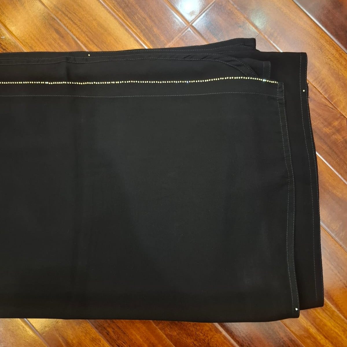 Black pants on a wooden floor