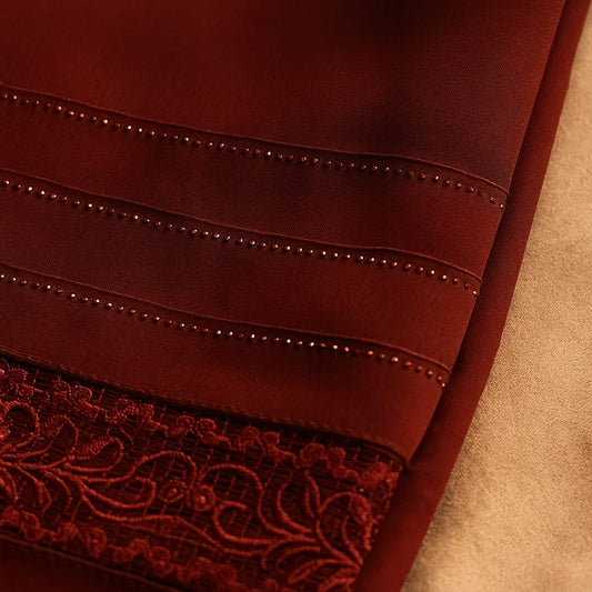 Close-up of a burgundy fabric with lace trim on a beige background