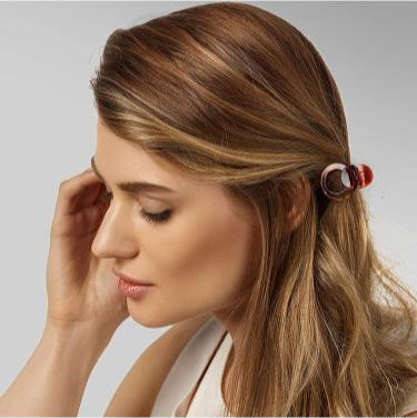 Woman with a hair clip in her hair against a neutral background